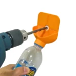 Recolector de polvo para taladro en color naranja, acoplado a una botella de plástico para la recolección de residuos mientras se perfora una pared